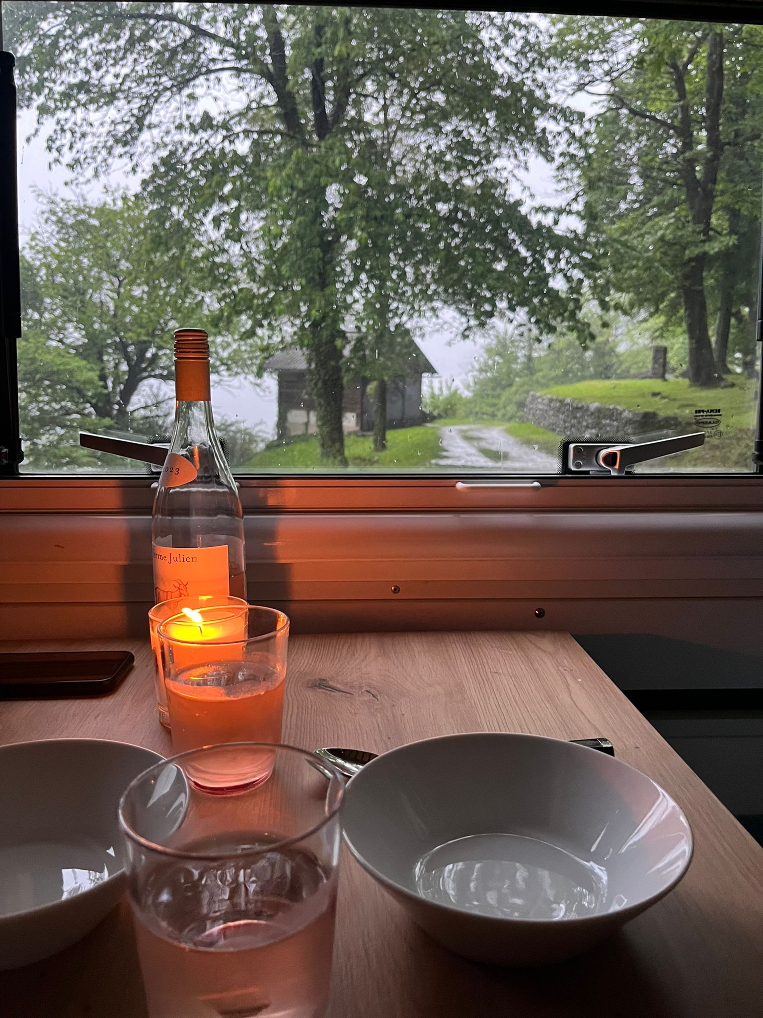 Kerzenlicht und Wein am Tisch, Blick aus dem Fenster